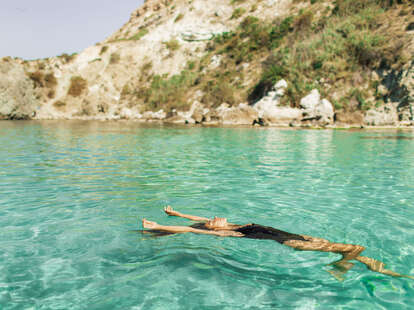 Woman in swimwear enjoying at beautiful turquoise colored water on tropical beach. 