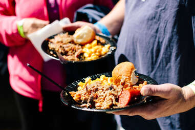 man holding a plate of barbecue at Beer, Bourbon & BBQ Festival atlanta