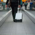 Traveling on a moving walkway at the airport with a suitcase