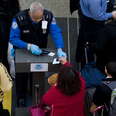 A Transportation Security Administration (TSA) official (2nd R) checks the identification of passengers prior to entering a security checkpoint at Ronald Reagan Washington National Airport in Arlington, Virginia, just outside Washington, DC, on December 2