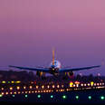 Airplane landing on the Barcelona airport at night with nice detail view of the illuminated track.