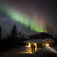 cabin beneath northern lights in alaska