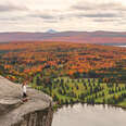 woman on cliff looking at autumn view