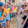 Oxfam Festival volunteers seen interacting with festival goers and filling water bottles at a Stage during the Fair Festival